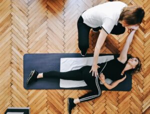 pilates teacher helping a student